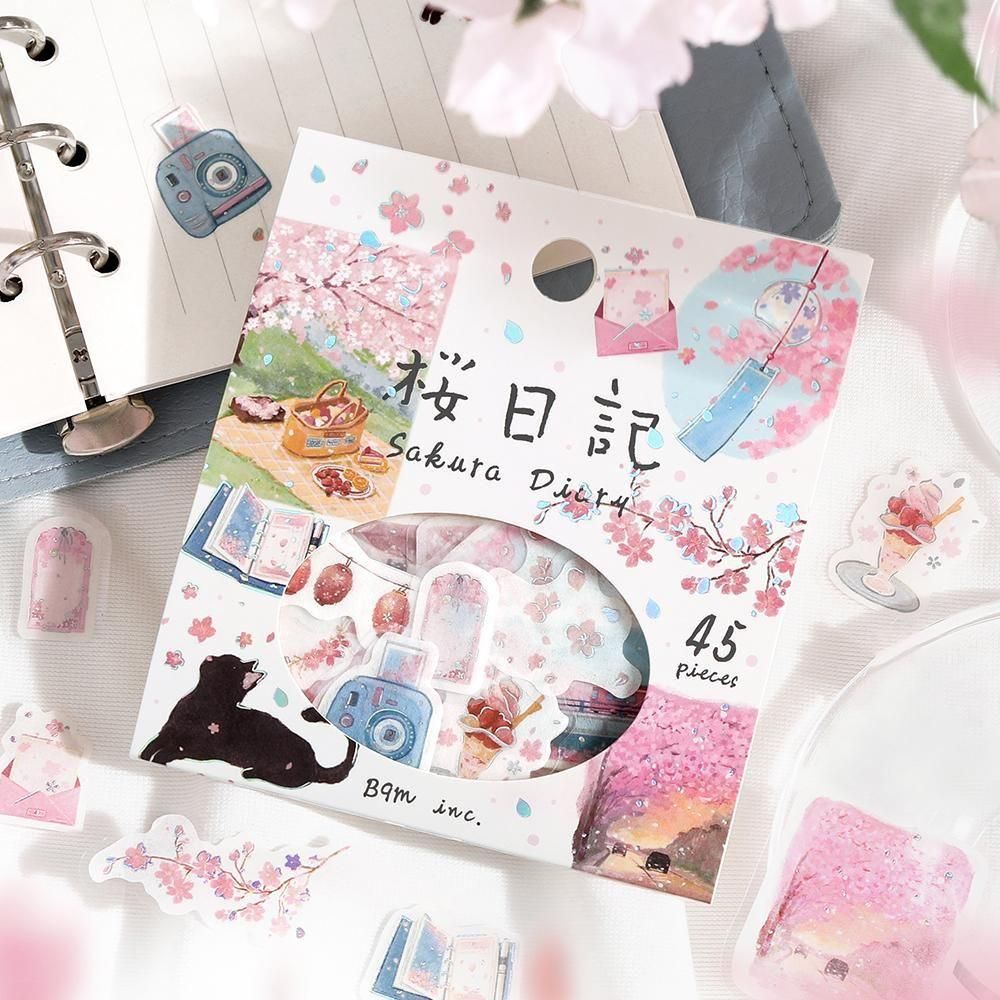 Packaging of Sakura Diary stickers with cherry blossoms and a cat illustration on a white surface.