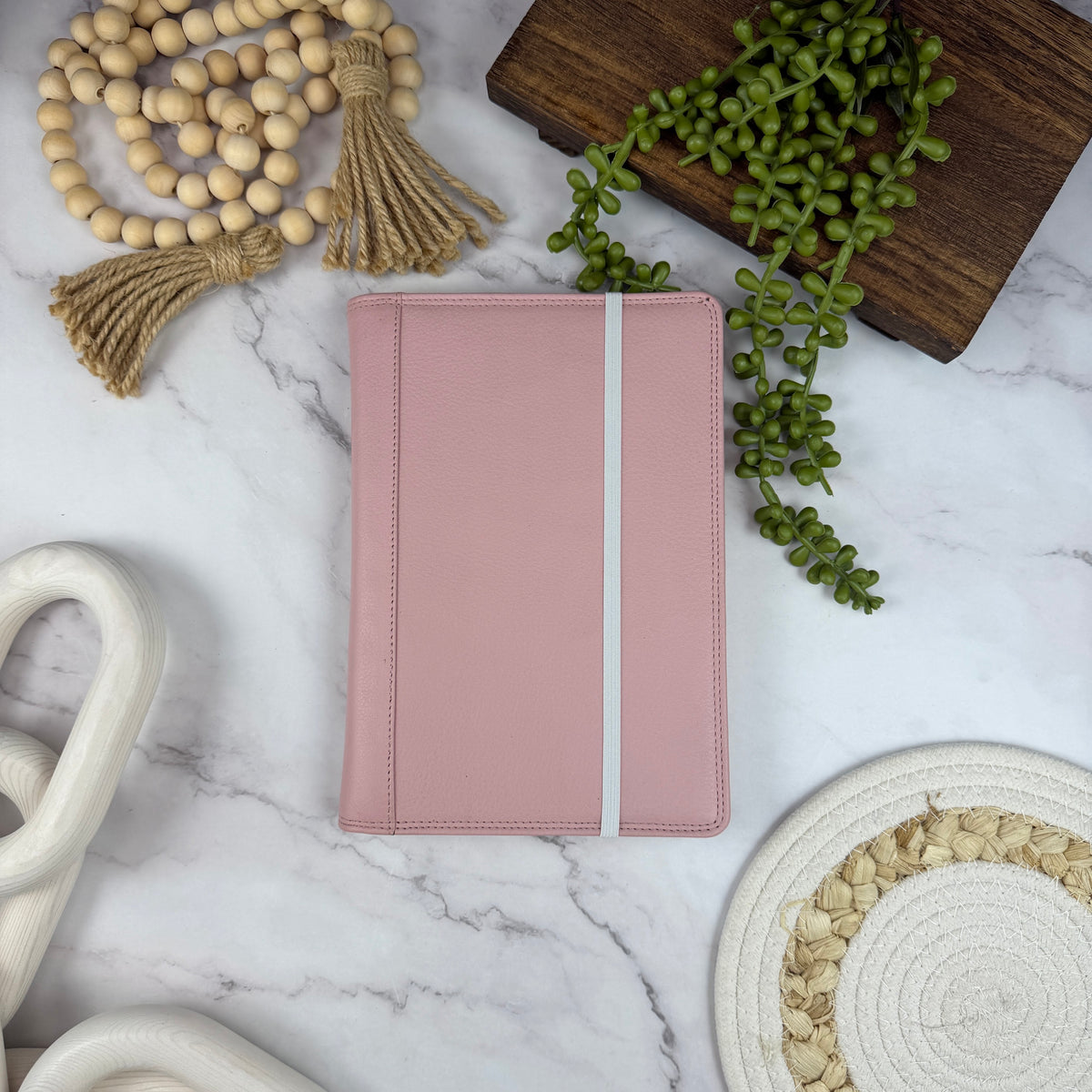 Girologio A5 Leather Notebook Cover in Blush Petal, closed with the notebook elastic in use
