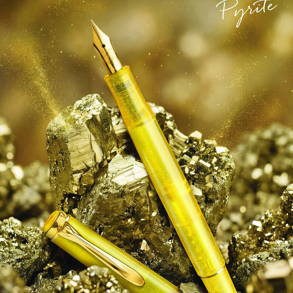 Pelikan Classic 200 Special Edition Pyrite fountain pen, capped and uncapped, resting on pyrite mineral rocks